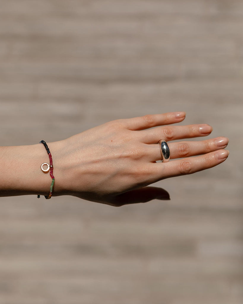 sapphires, emeralds and rubies beaded bracelet handstrung on silk thread handcrafted in London with 9ct solid gold organic charm by Maya Magal London